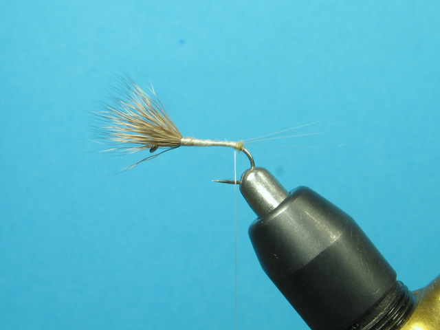 Let the bobbin hang and dub the thread enough to reach the wing